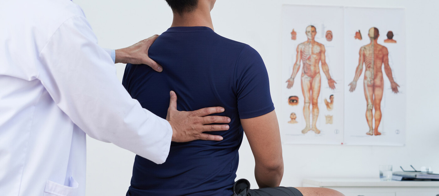 A provider examines a patient's back